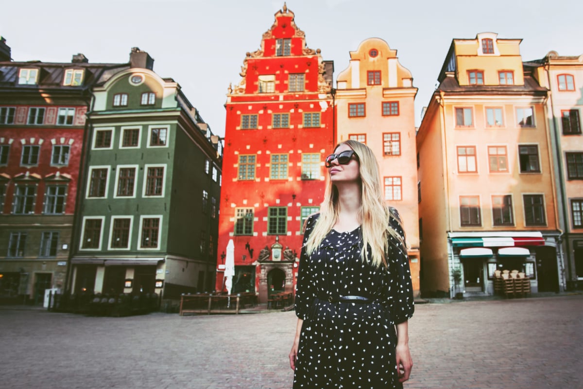 solo female traveler wandering around a colorful square in stockholm sweden